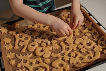 Obraz na płótnie Canvas boy makes christmas cookies with caramel to celebrate christmas with his family
