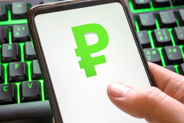 Smartphone with ruble symbol on screen phone with technology green colored keyboard background
