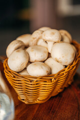 wicker basket with champignon mushrooms on a dark background