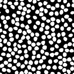 Free hand drawn specks, spots, blobs, splashes seamless pattern. Uneven speckles, flecks, stains or dots of different size texture. Unusual polka dot white on black abstract monochrome background.
