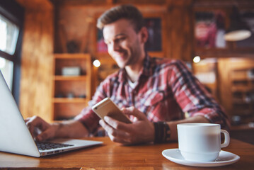 Fototapeta premium Young businessman with gadget at cafe
