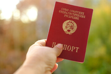 passport of citizen of the USSR, old personal document for travel in red cover in female hand,...