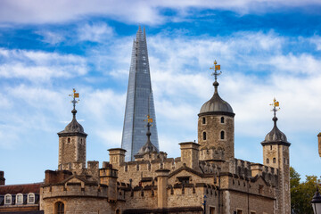 Fototapeta na wymiar Historic Brick Building, Tower of London, in a modern city during cloudy blue sky morning. London, United Kingdom. Travel Destination