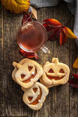 Linzer cookies in the shape of a Halloween pumpkin on wooden table. Top view.