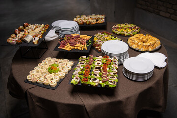 Cattering. Dark concrete business building hallway with table full of food.