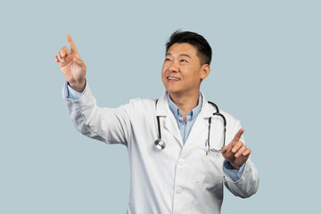 Happy middle aged chinese male therapist in white coat controls virtual screen with hands on empty space