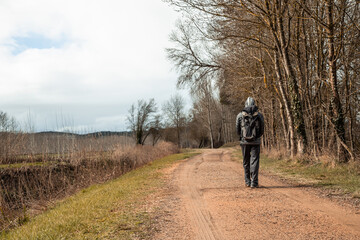 Young man walking down a path in fall.