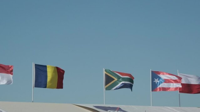 Romania, South Africa, Puerto Rico and Monaco flags waving in slow motion together.