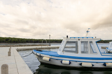 A boat in the small port of Kusljun, Krk, Croatia. On the island (Oticic Kosljun) a Franciscan Monastery  can be found.