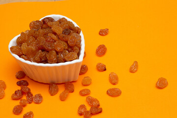 bowl full of raisins on a colored background