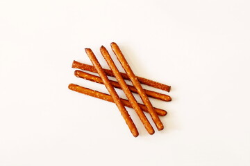 Salted Baked brown Pretzel Sticks on white background,top view,copy space