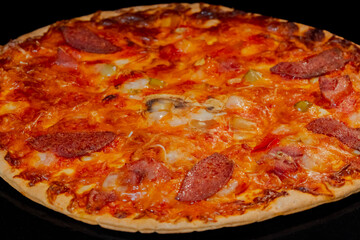 Burnt pizza with sausage, mushroom, pepper, cheese on tray in electric oven - macro, close up view. Italian cuisine, homemade bakery, failure, problem, fast food concept