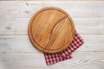 Empty pizza board and napkin on white wooden top view.