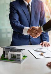 Shake hand Real estate brokerage agent Deliver a sample of a model house to the customer, mortgage...