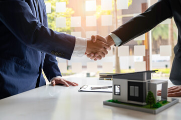 Shake hand Real estate brokerage agent Deliver a sample of a model house to the customer, mortgage loan agreement Making lease and buy and sell house And contract home insurance mortgage loan concept