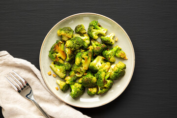 Homemade Pan-Fried Broccoli on a Plate on a black background, top view. Flat lay, overhead, from above.