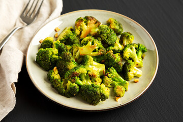 Homemade Pan-Fried Broccoli on a Plate on a black background, side view. Close-up.