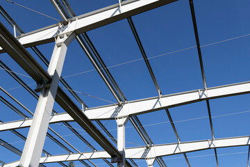 Steel structure of the production hall. Steel scaffolding against the blue sky.