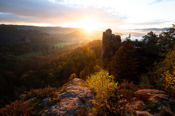 Sonnenaufgang mit Wolken und Nebel im Herbst auf der Bastei mit Blick auf den Mönch im...