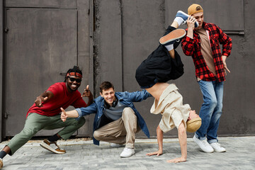 Full length shot of all male hip-hop team posing outdoors and looking at camera