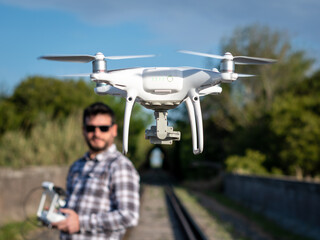 Hombre con lentes jugando con su drone en vuelo. Fotografía con enfoque selectivo en el drone