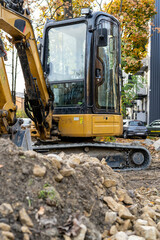 Orange excavator on the road.  Construction works in the city.