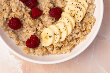 Bowl of oatmeal, banana and raspberries