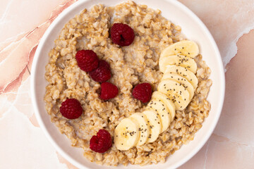 Bowl of oatmeal, banana and raspberries
