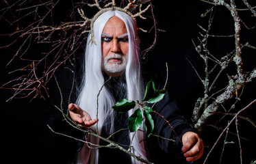Devil man on Halloween night. Bearded male in witcher costume. Sinister sorcerer vampire. Horror.