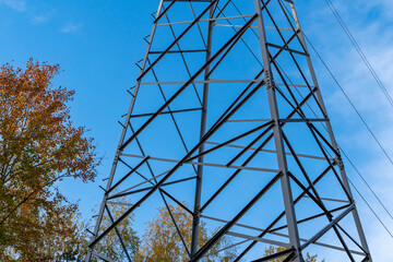 Electric station for supplying electricity to city, village. High voltage electric tower. Close-up. Power line against blue sky.