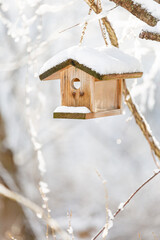Obraz na płótnie Canvas Wooden Birdhouse in winter (vertical)