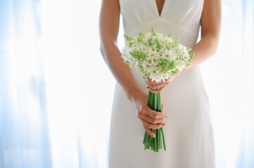 Unrecognizable bride holding wedding bouquet