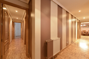 Corridor of an urban residential house with parquet floor and two-tone walls, brown and white