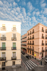 Facades of old residential buildings at a crossroads on a day with blue skies and clouds