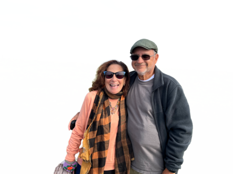 Happy retired heterosexual older couple wearing sunglasses and smiling 