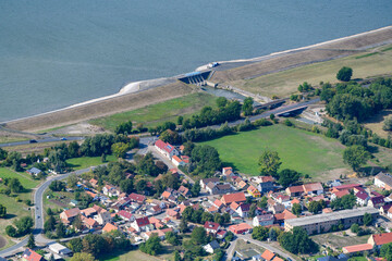 Die Staumauer des Hochwasser-Rückhaltebeckens Straußfurt und Teile der Ortslage Vehra.