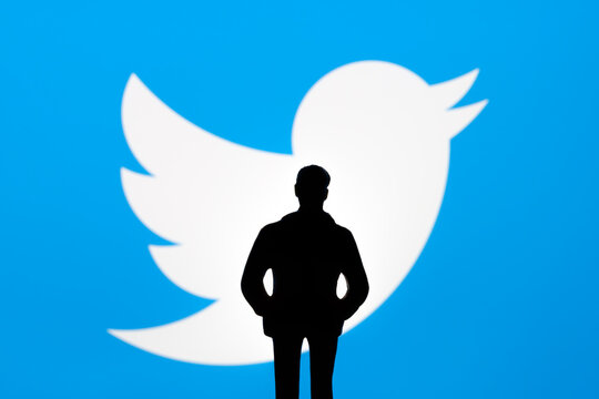 Twitter and Elon Musk deal concept. Toy figurine silhouette is seen in front of blurred Twitter logo on display. Stafford, United Kingdom, October 26, 2022.