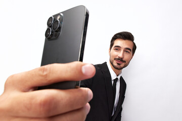 Business man takes selfies on phone with smile with teeth in business suit on white isolated background close-up on wide-angle lens 