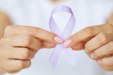 Womans hands holding purple domestic violence awareness ribbon