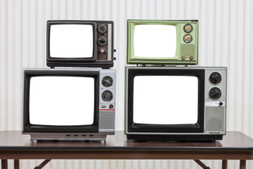 Four vintage televisions on table with cut out screens.
