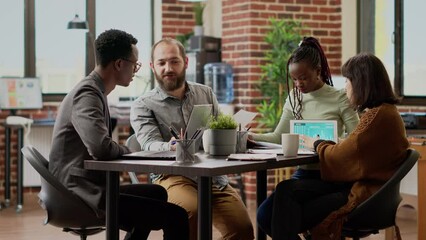 Multiethnic team of people working on business collaboration, brainstomring ideas to plan research presentation. Meeting in boardroom to do teamwork on report project. Tripod shot.
