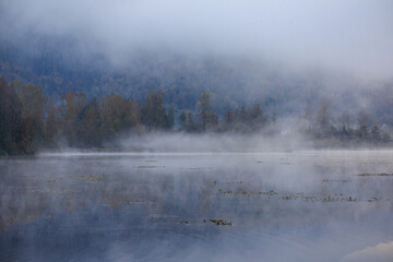 Obraz na płótnie Canvas Lake looks serene on a foggy October morning