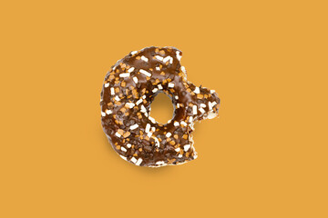 Creative concept of biting eating delicious sweet sugar brown black doughnut donut with glaze on brown background. Top view flat lay unhealthy dessert, Food concept, mock up, copy space