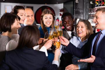 International group of glad cheerful smiling businesspeople toasting with champagne, having fun at office party in nightclub