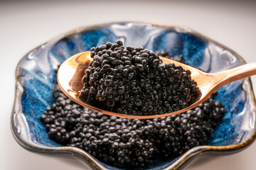 Fototapeta na wymiar Luxury Black caviar in golden spoon, Texture of expensive luxury caviar. Food concept.