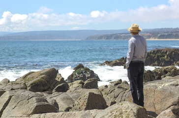 hombre admirando las olas del mar en las rocas