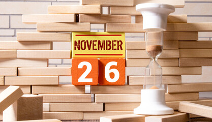Wood calendar with date and old clock. Tuesday 26 November