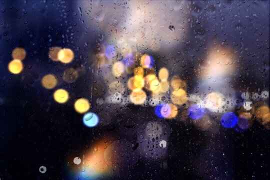 defocus evening windows glass with rain drops and car traffic blurred light rainy season background template