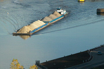 Large barge carrying gravel and sand along the river bank near Minneapolis Minnesota USA