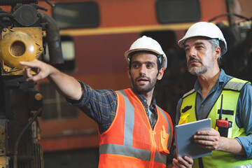 professional technician engineer with safety hard hat working to maintenance construction equipment...